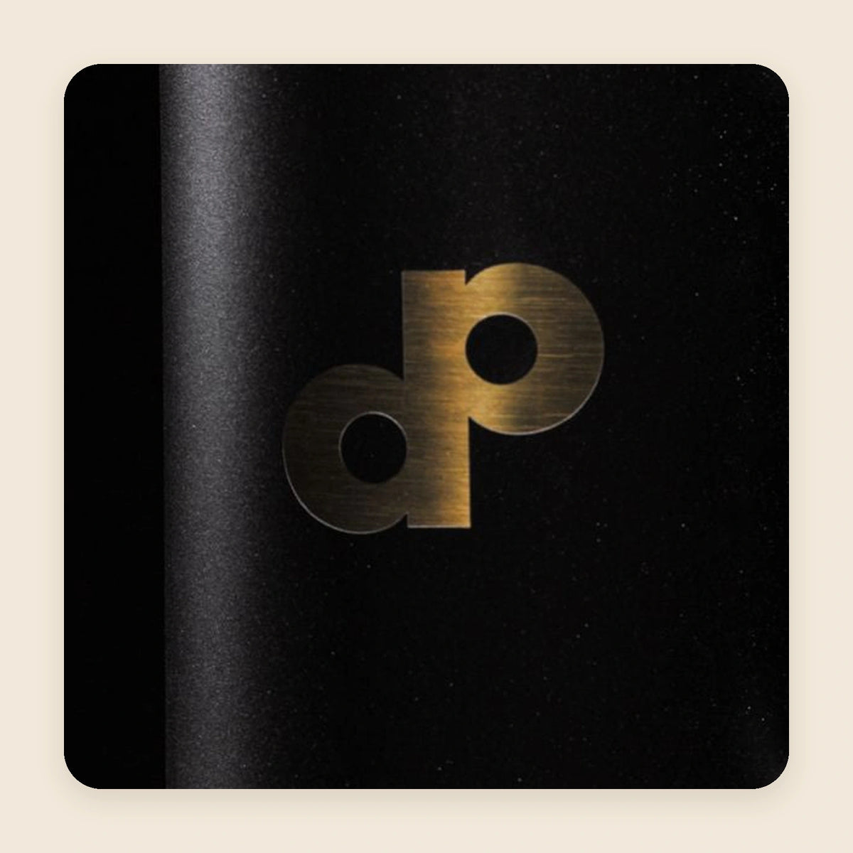 Gold DP mark on the black High Roller tumbler, shown close up.