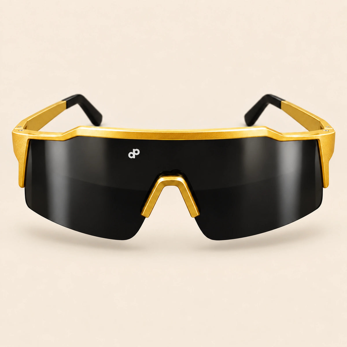 Full front view of the gold High Roller sunglasses with a single black shield lens and white DP mark, floating on cream.