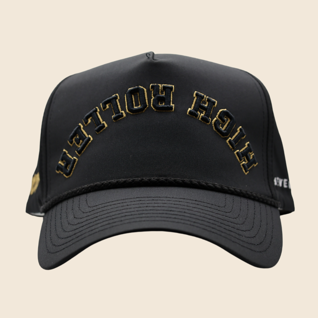 Front view of a black High Roller hat with gold lettering