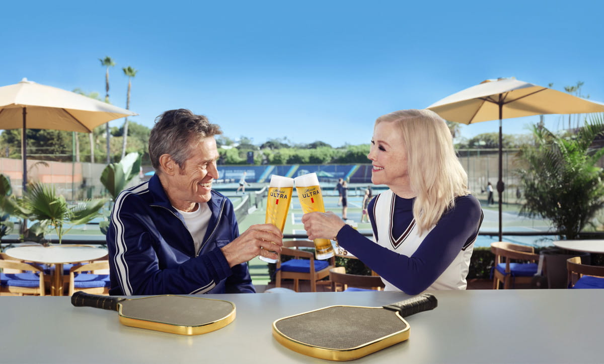 Promo photo of Willem Dafoe and Catherin O'Hara celebrating their pickleball victories thanks to The High Roller Pickleball Paddles from Dope Pickleball Co