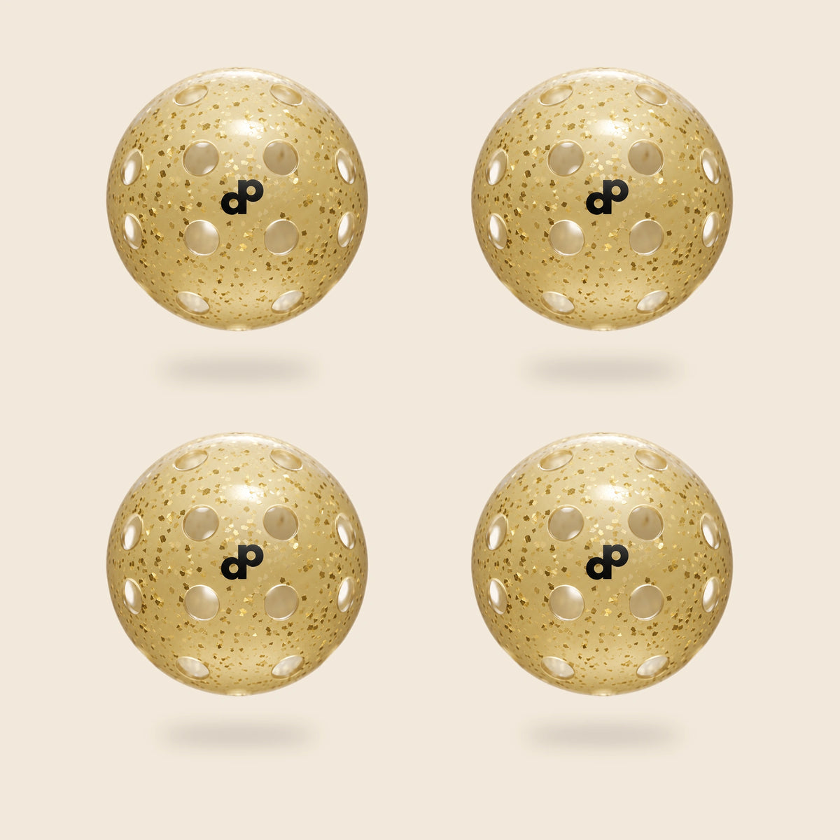 Four DOPE High Roller gold-glitter pickleballs with black DP logos and circular open holes, floating on cream.