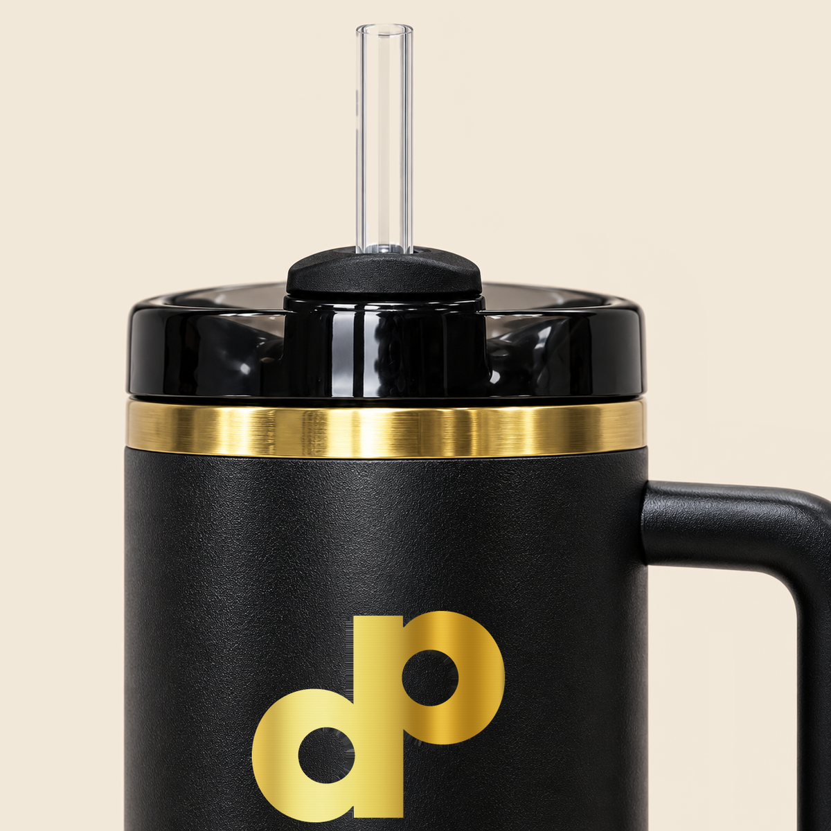Close detail of the clear straw, glossy black lid, brushed gold rim and powder-coated body of the High Roller tumbler.