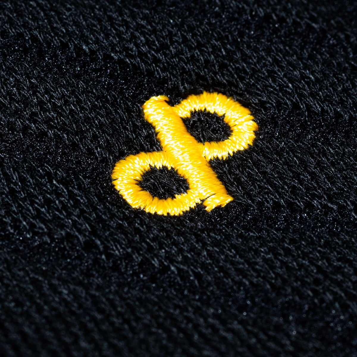 Actual gold DP embroidery and black knit texture on a High Roller sock, shown close up.