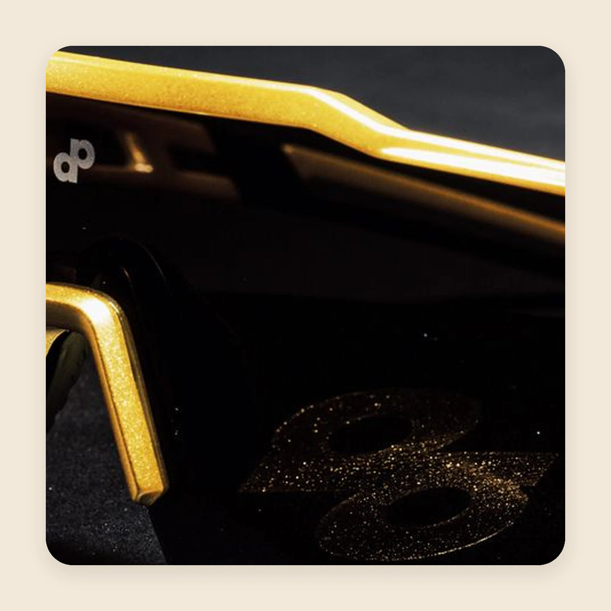 High Roller sunglasses with black lenses, a gold frame, and gold nose details, shown close up.