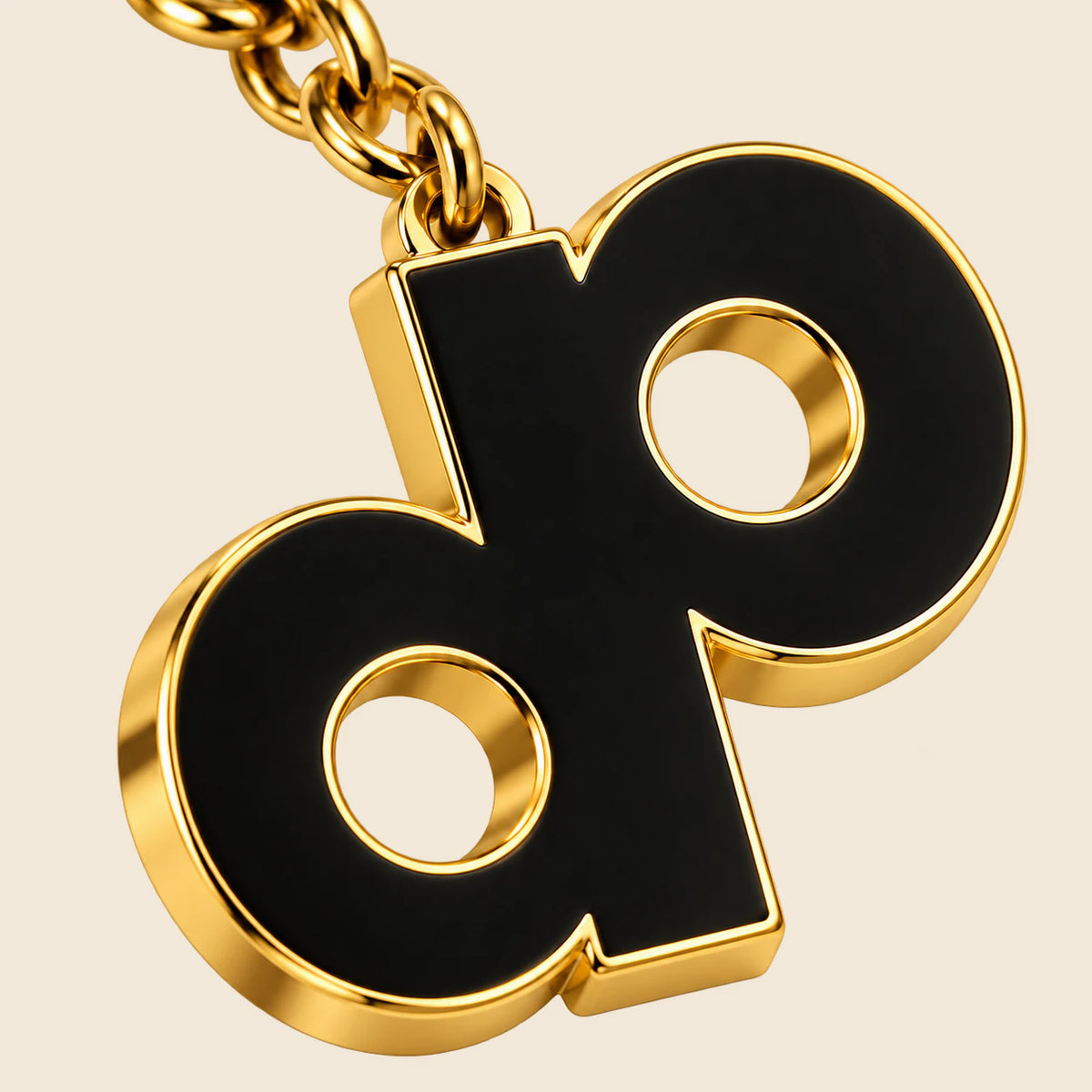 Close-up of the gold-tone metal edge, black enamel face and circular DP logo cutouts.
