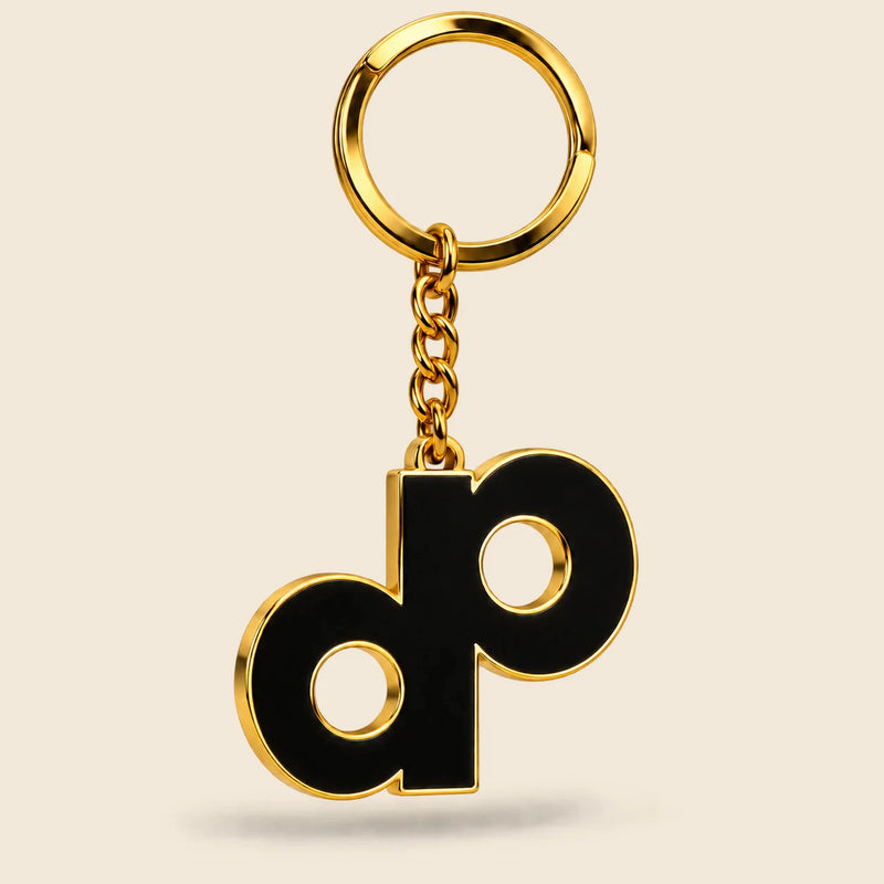 High Roller DP logo keychain with black enamel, gold-tone metal edges, short chain and split ring.