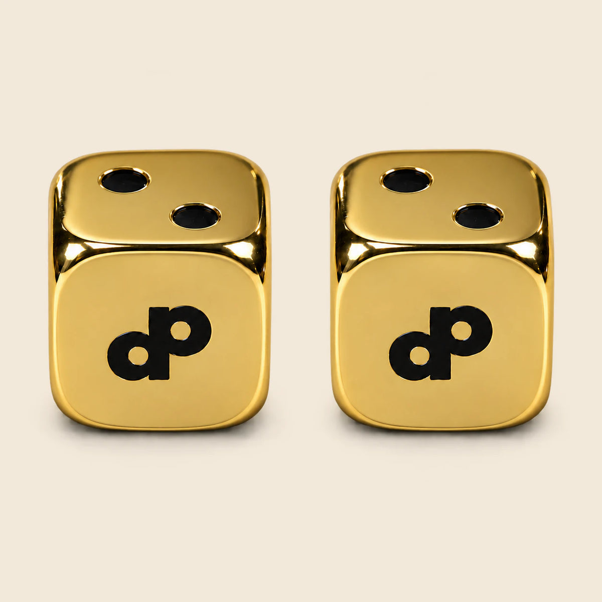 Two High Roller gold metal dice with smooth gold faces and black DP logos.