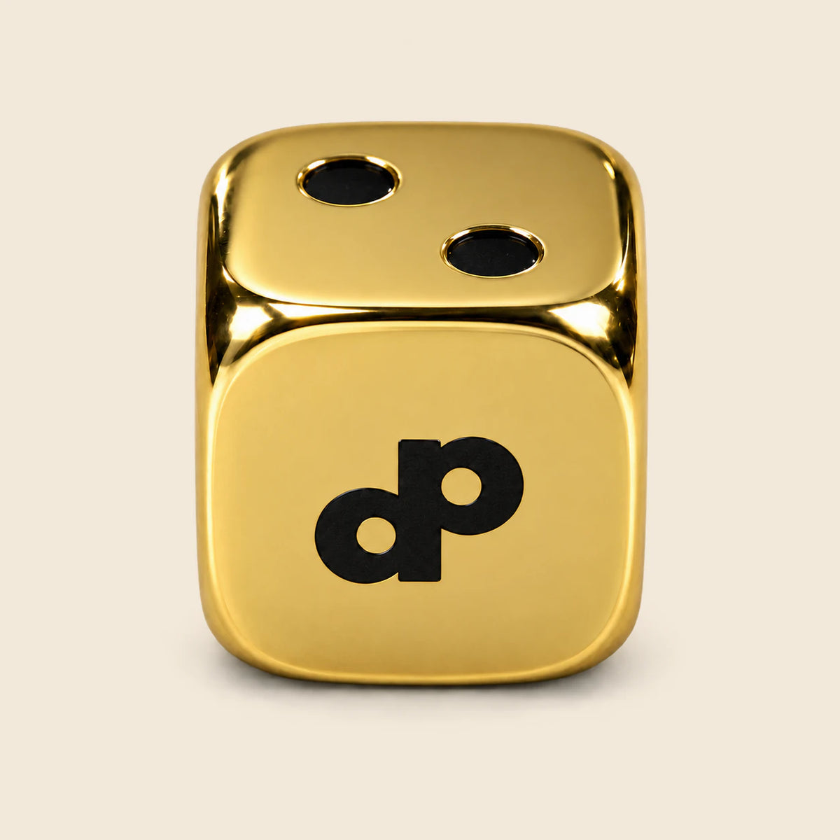 High Roller gold metal die with smooth polished gold faces, black DP logo and two recessed black pips.