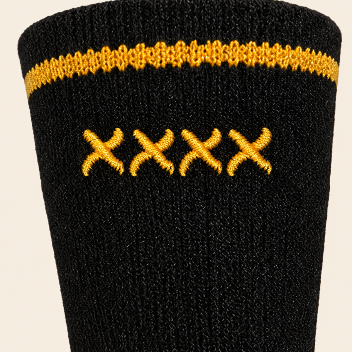 Close detail of four curved gold x stitches and the gold stripe on a black High Roller sock cuff.