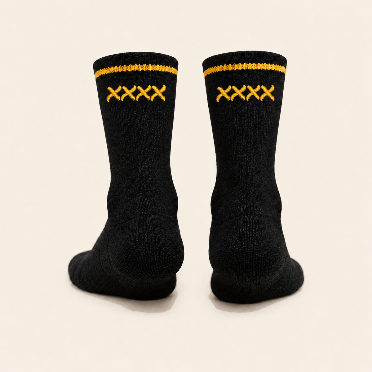 Rear studio view of black High Roller socks with four curved gold embroidered x marks beneath each cuff stripe.