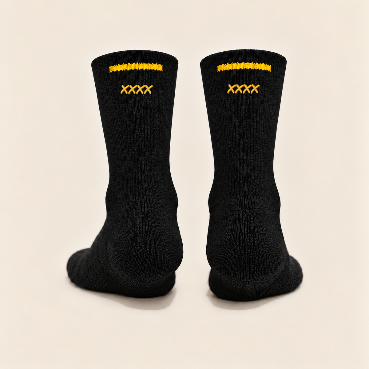 Full rear view of the black High Roller sock pair on theme cream, with fine black knit, four small gold satin embroidered Permanent Marker Xs beneath each rear cuff stripe and cuff-line side gaps.