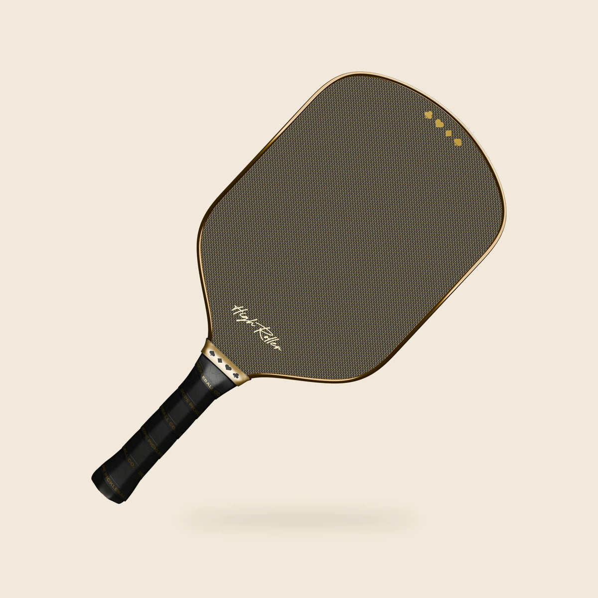 High Roller chrome-gold paddle angled with its head upper-right and handle lower-left, showing the woven face, script, gold suit band and black grip.