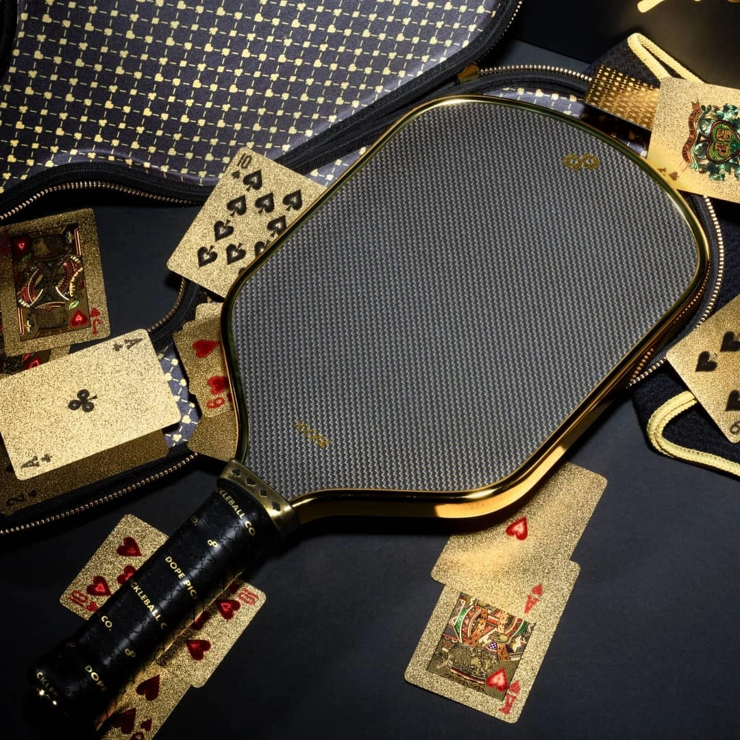 Original High Roller Hybrid paddle photographed with an open travel case and gold playing cards. One paddle and edge protection adhesive strip included; case and props sold separately.