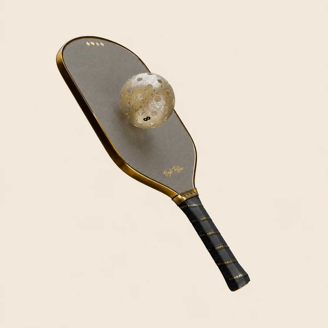 High Roller metallic gold pickleball paddle with gold glitter pickleball, studio composition. Ball sold separately.