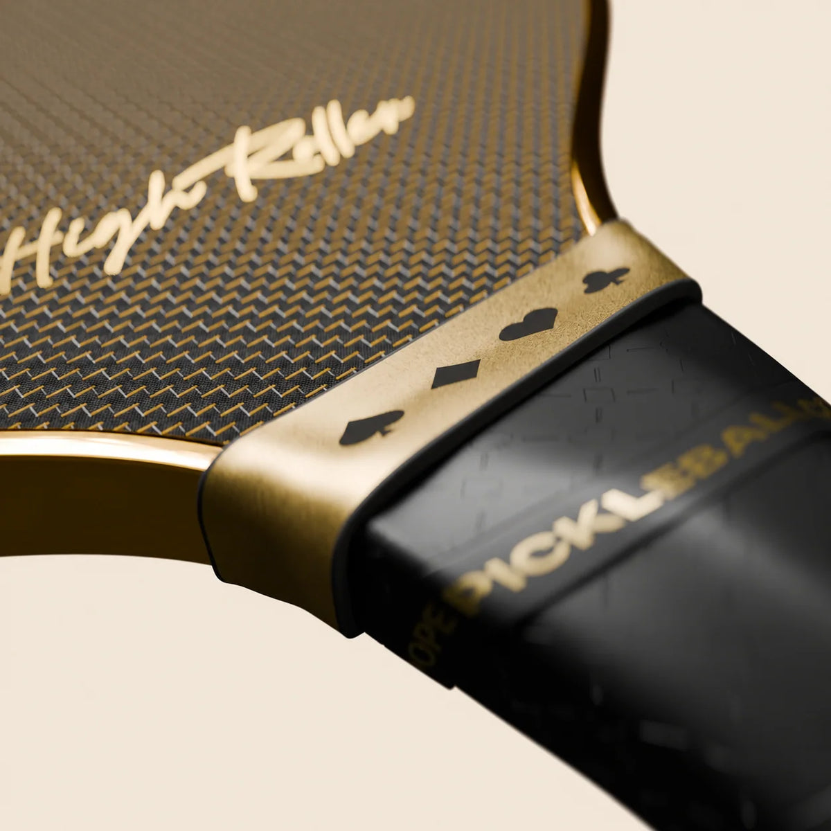 High Roller paddle close-up showing the woven face, gold script, metallic gold finish outline and four card suits on the collar.