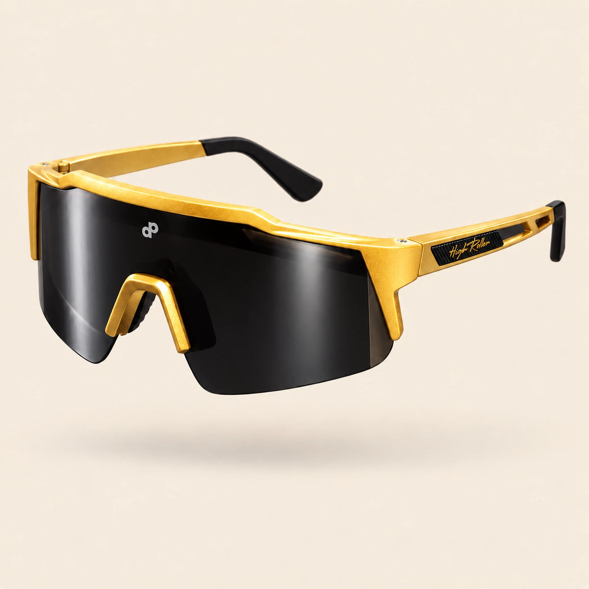 Full three-quarter view of the gold High Roller sunglasses with a single black shield lens, white DP mark and High Roller exterior temple detail, floating on cream.