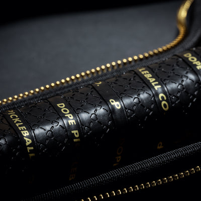 Close-up of a black High Roller paddle grip with gold lettering inside a black case